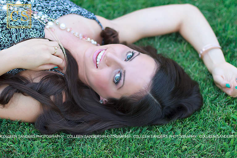 Nicole's senior portraits with her flower romper laying in the grass, gorgeous blue eyes by Colleen Sanders Photography.