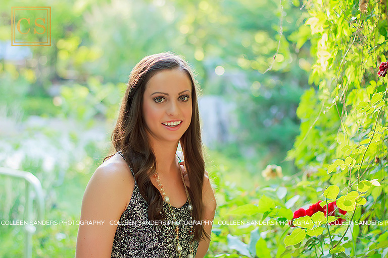 Nicole's senior pictures by senior photographer Colleen Sanders, captured golden hour back light, with natural greenery and flowers including red roses.